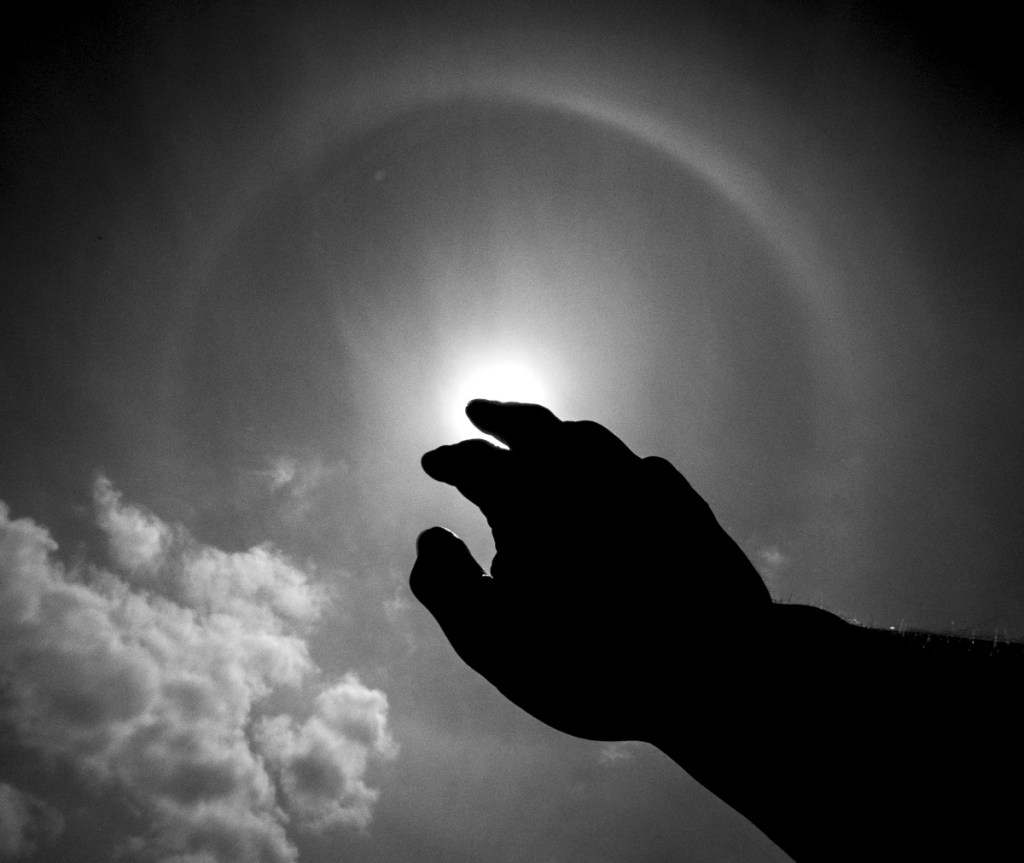 A finger pointing away to the sun