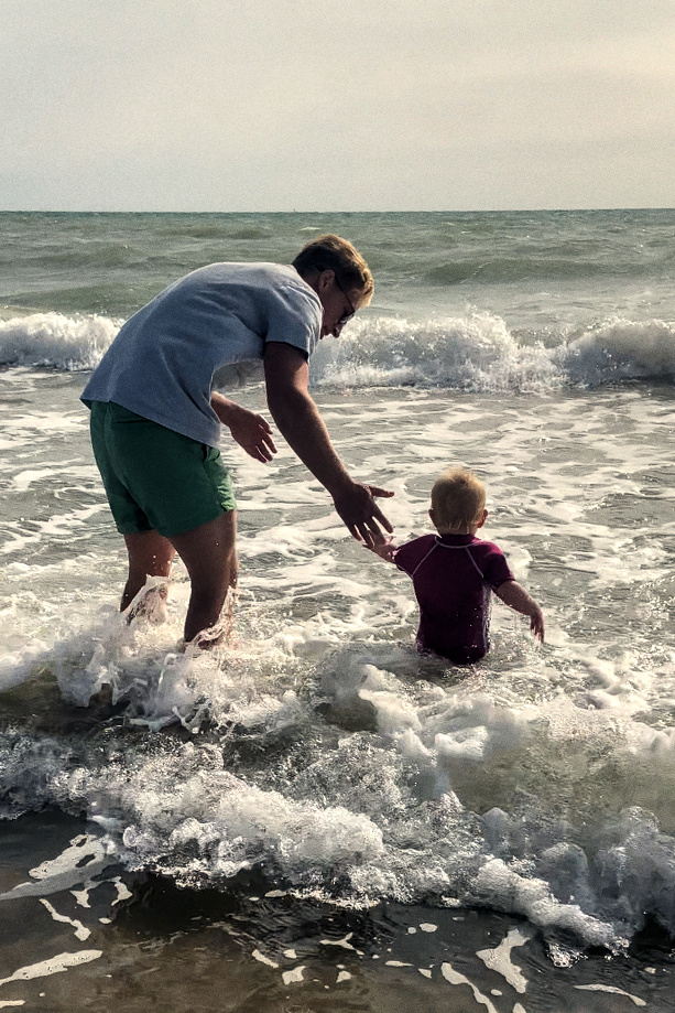 A father hovering over his daughter in the sea